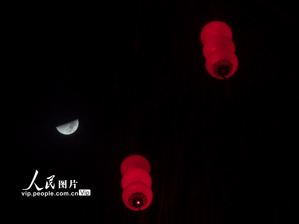 2026年2月24日，在山西省武鄉縣，新春彩燈映襯下的上弦月格外亮眼。李勇攝（人民圖片網）