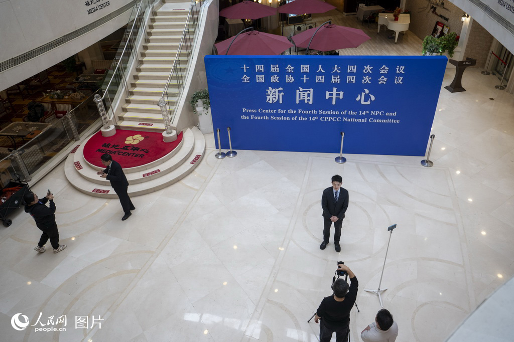 2月27日,媒体记者在全国两会新闻中心采访拍摄。人民网记者 翁奇羽摄