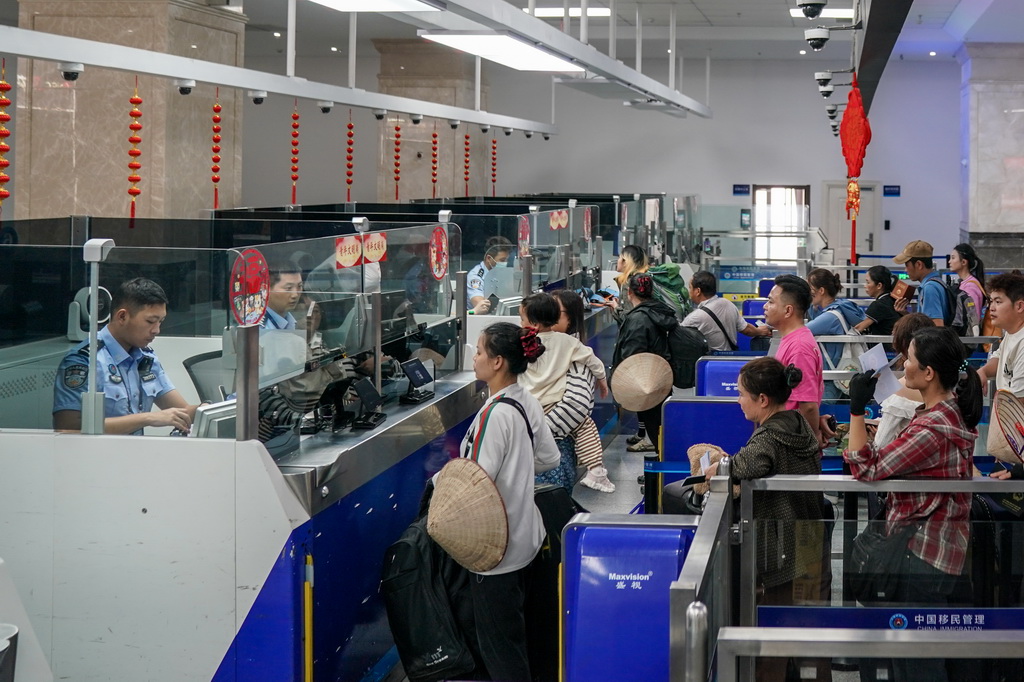 2月26日，河口边检站执勤民警为旅客办理边检手续。