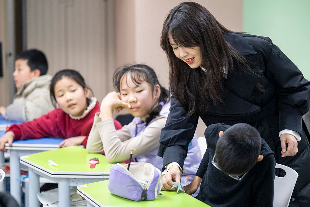2月4日,在恩施州婦女兒童發展與服務中心寒假公益托管班,張瓊麗與小朋友們互動。