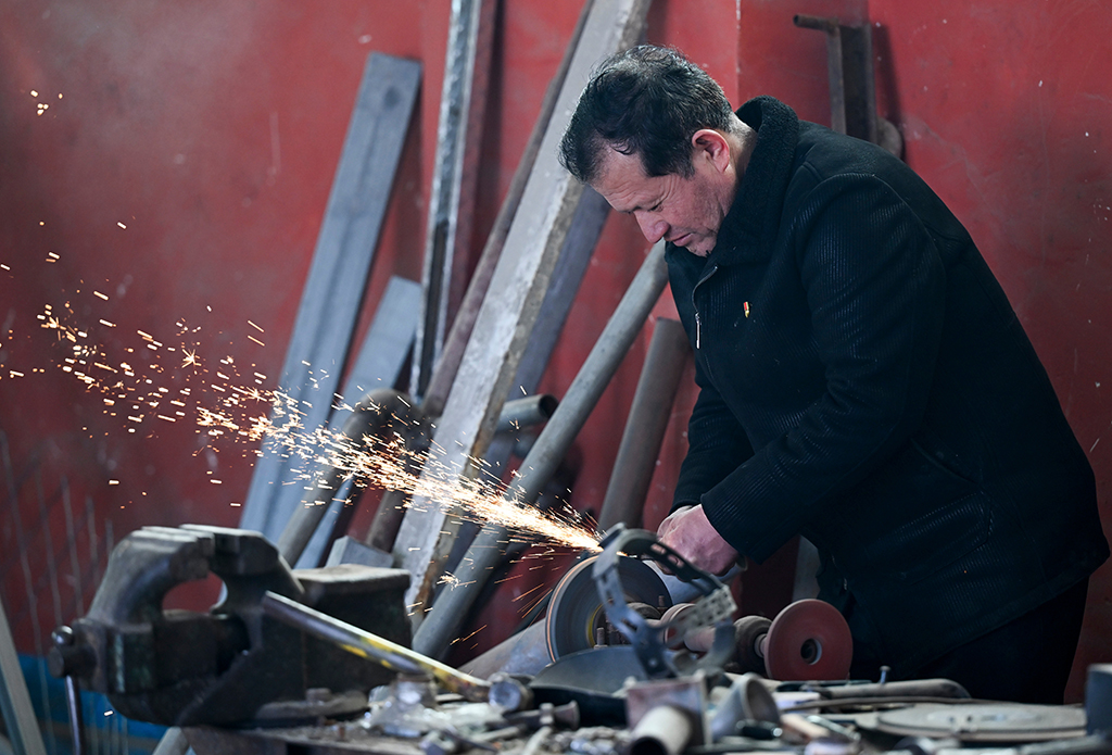 2月9日,在伊犁哈萨克自治州新源县克热格塔斯村,木沙江·海拉特在自己家中的工坊里工作。新华社记者 王菲 摄