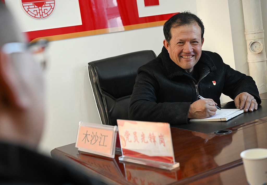 2月9日,在伊犁哈萨克自治州新源县,木沙江·海拉特在克热格塔斯村党群服务中心与来访的群众交流。新华社记者 王菲 摄