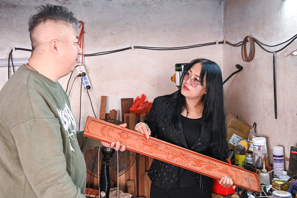 2月7日,在廣西東興市,蘇海珍(右)與獨弦琴制作匠人討論琴身材質和紋飾。