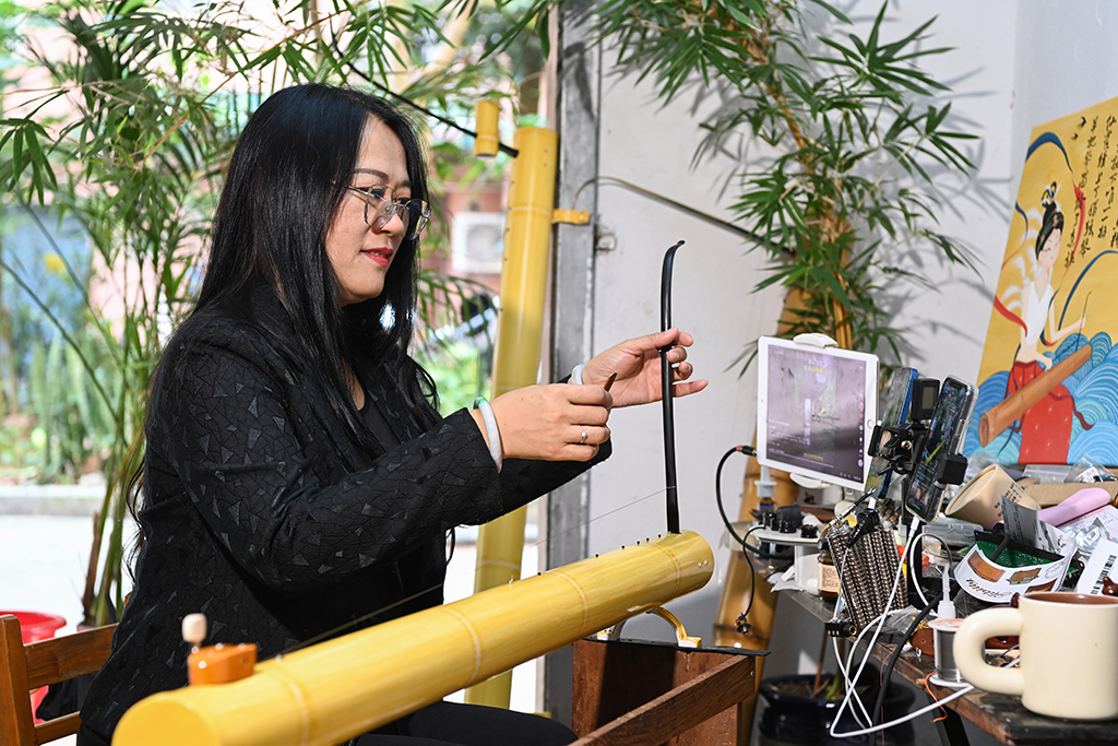 2月7日，苏海珍在位于广西东兴市的工作室内通过手机直播向网民演奏独弦琴。