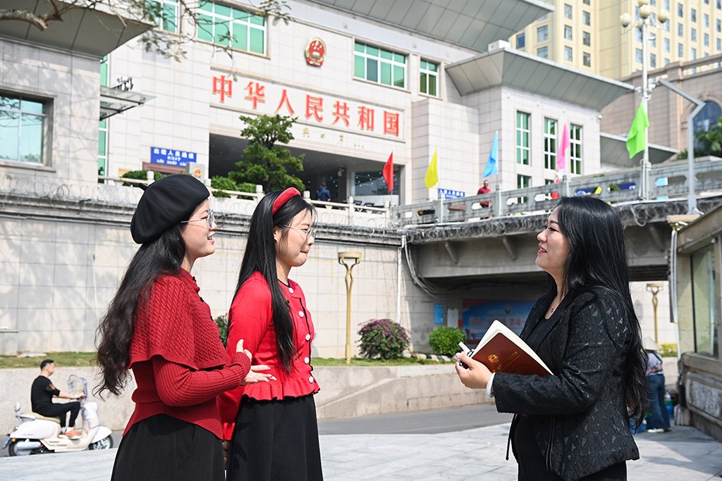 2月7日,蘇海珍(右)在東興口岸附近向外地游客了解旅游體驗。