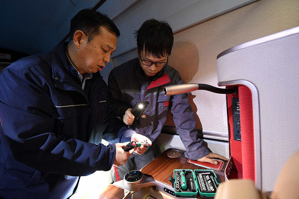   1月14日，在中國鐵路西安局集團有限公司西安動車段動車組檢修庫的待檢列車上，董宏濤（左）和同事探討業務。