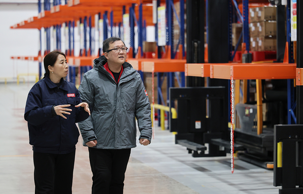 2月26日，在伍爾特（天津）電子有限公司，郭紅靜（左）調研智慧倉儲運行情況。新華社記者 李然 攝
