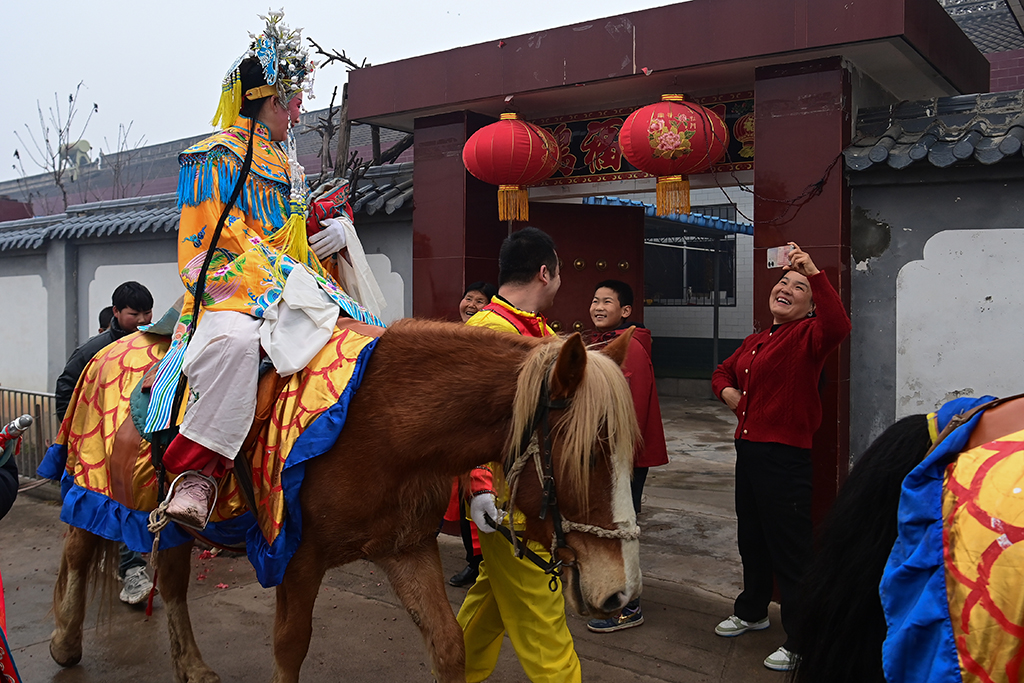 3月2日，陇县黄花峪村村民在家门口迎接社火队。
