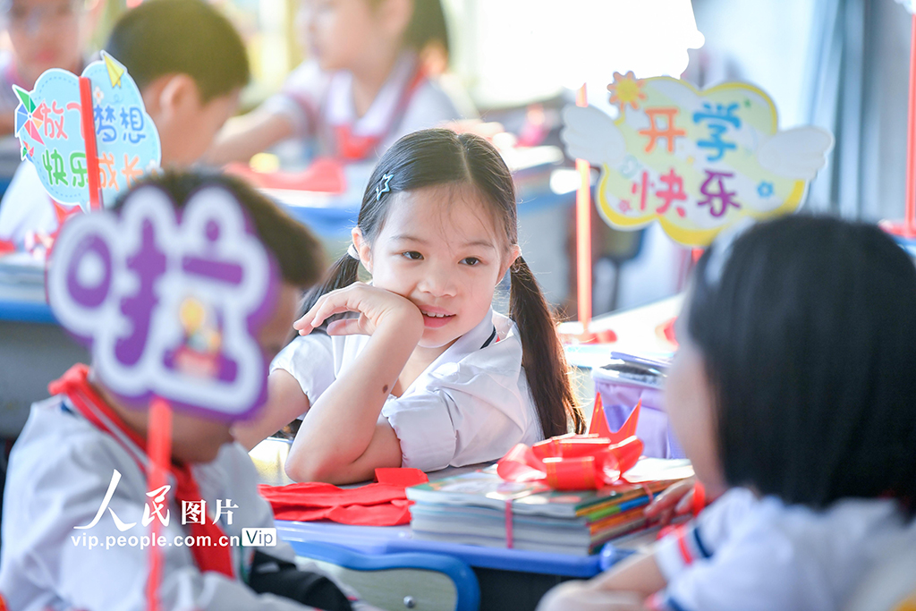 2026年3月1日,海南海口市中小学校学生返校报到。在海口市港湾小学,学校将新课本打包成“新学期礼物”,并为同学们发放崭新的红领巾。苏弼坤摄(人民图片网)