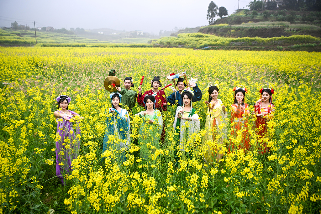 3月3日，漢服愛好者在油菜花田中合影。近日，重慶市永川區仙龍鎮的萬余畝油菜花競相綻放，宛如一片金色海洋。
