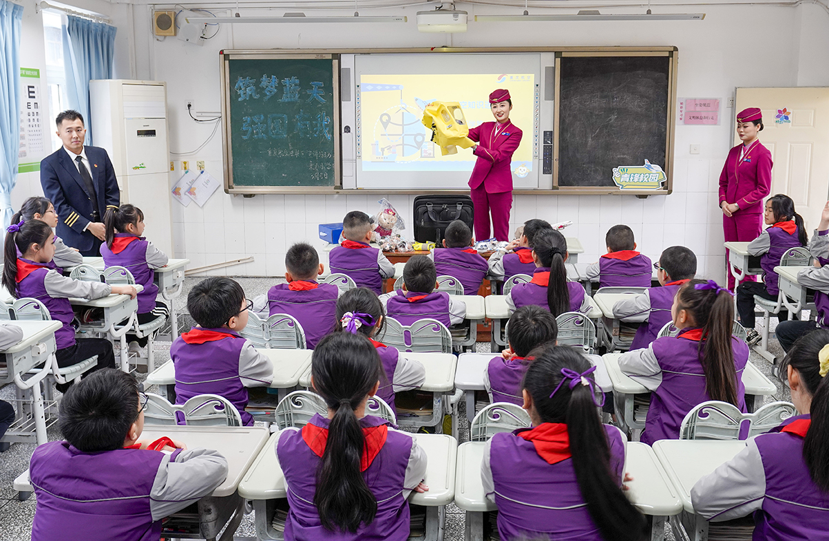 3月5日,在重庆市九龙坡区谢家湾朵力小学校的课堂上,来自重庆航空的空乘人员为学生们演示如何正确使用客机上的应急处置装备。