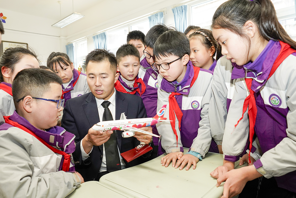 3月5日,在重慶市九龍坡區謝家灣朵力小學校的課堂上,來自重慶航空的飛行員李蒙邑用飛機模型向學生們講解飛行原理。