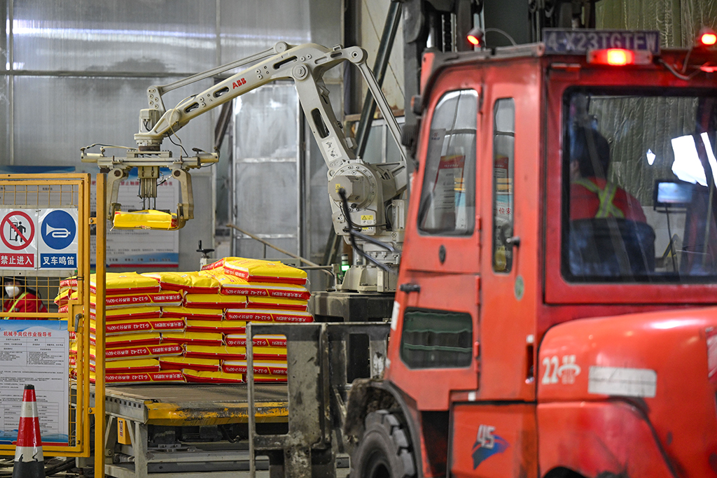 在位於新疆昌吉回族自治州瑪納斯縣的新疆心連心能源化工有限公司，自動碼垛機器人在生產線上作業（3月4日攝）。