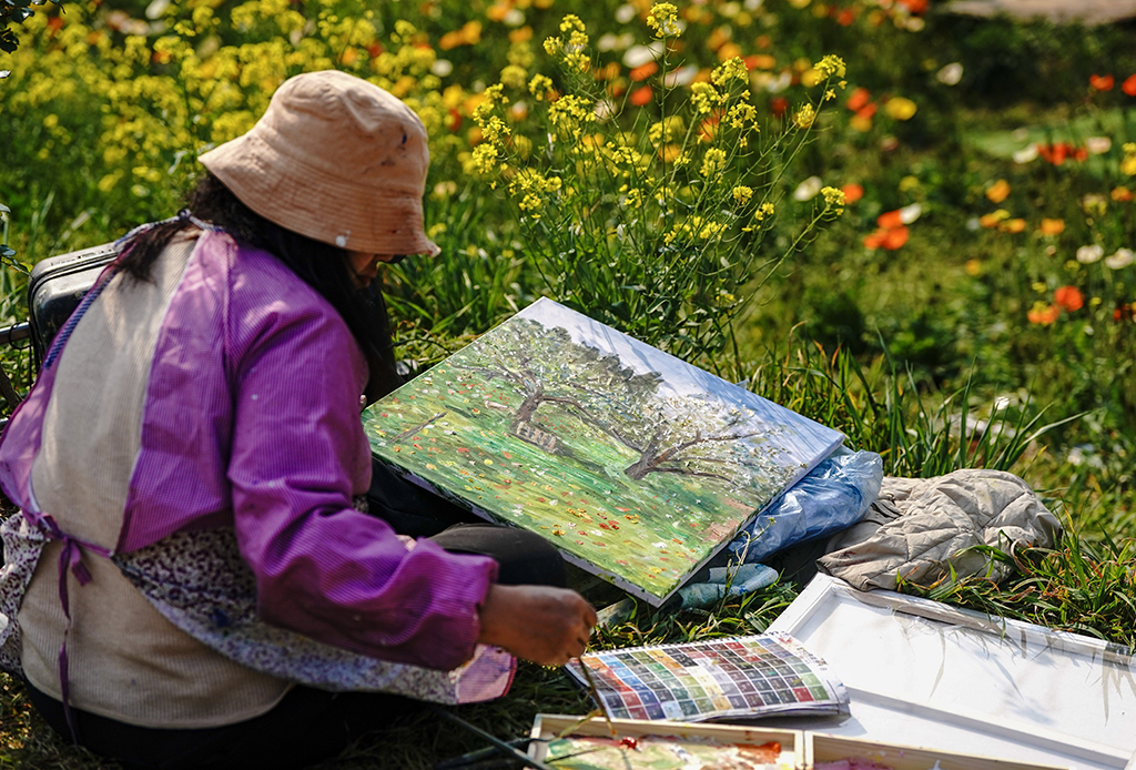 3月10日，一名油畫愛好者在昆明名花谷寫生。