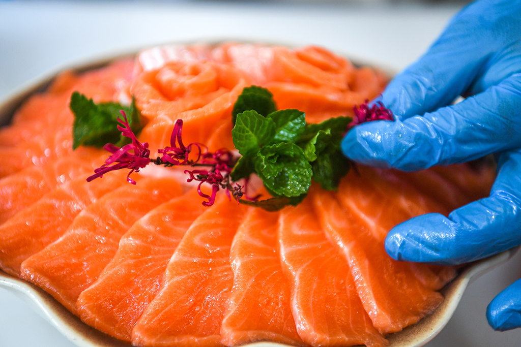 3月10日,工人在貴州省岑鞏縣淡水漁業基地將三文魚切片擺盤。