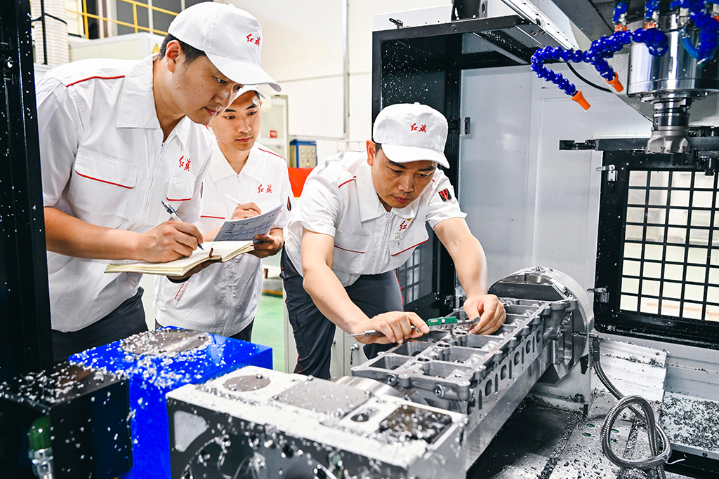 2023年6月8日，楊永修（右）在中國一汽研發總院檢查試制零部件的精度。新華社記者 許暢 攝