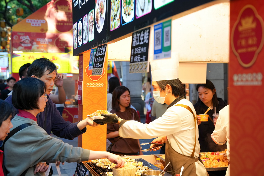 3月12日，在廣州市越秀區北京路步行街區舉辦的美食廟會上，市民、游客在品嘗美食。