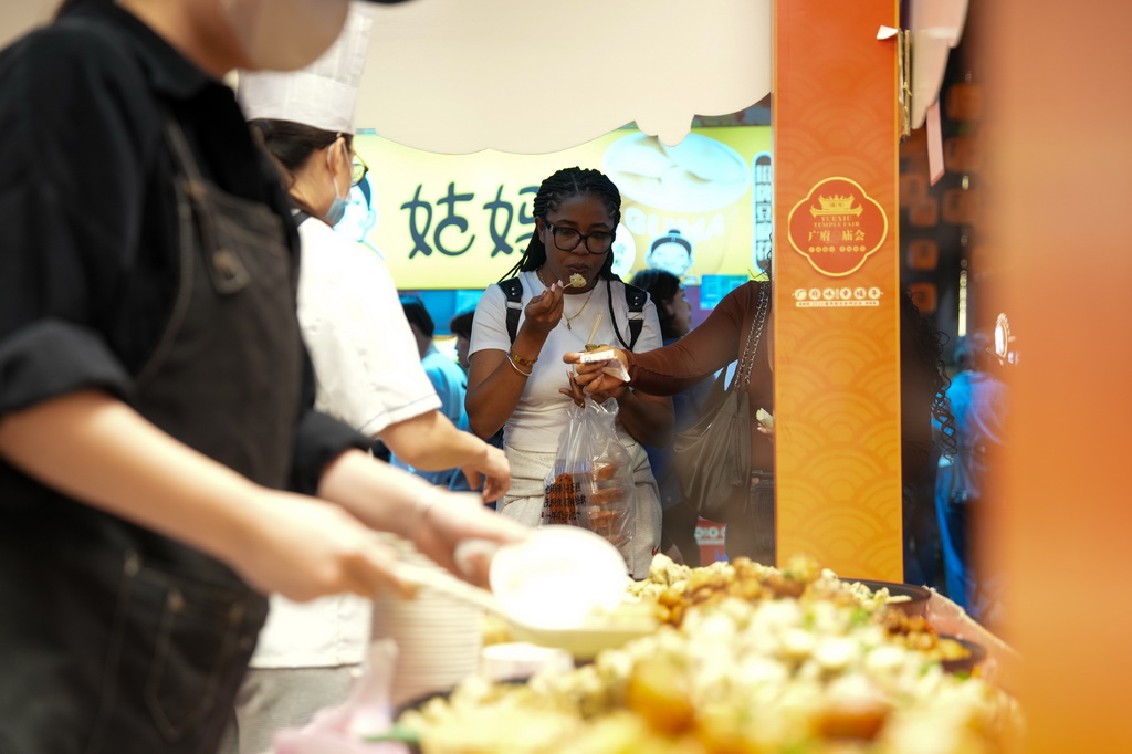 3月12日，在廣州市越秀區北京路步行街區舉辦的美食廟會上，外國游客在品嘗美食。
