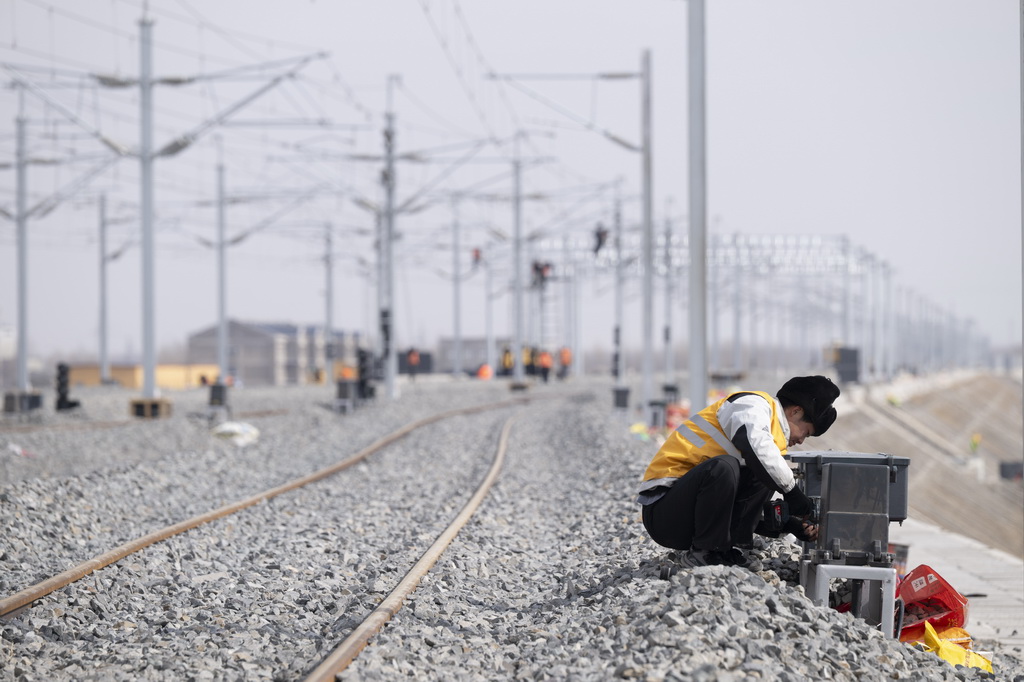 3月13日,工人在哈伊高铁绥化南站施工现场安装信号设备。