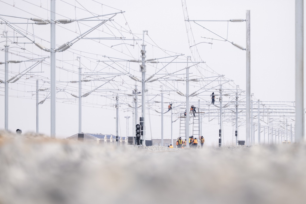 3月13日，工人在哈伊高鐵綏化南站施工現場進行接觸網作業。