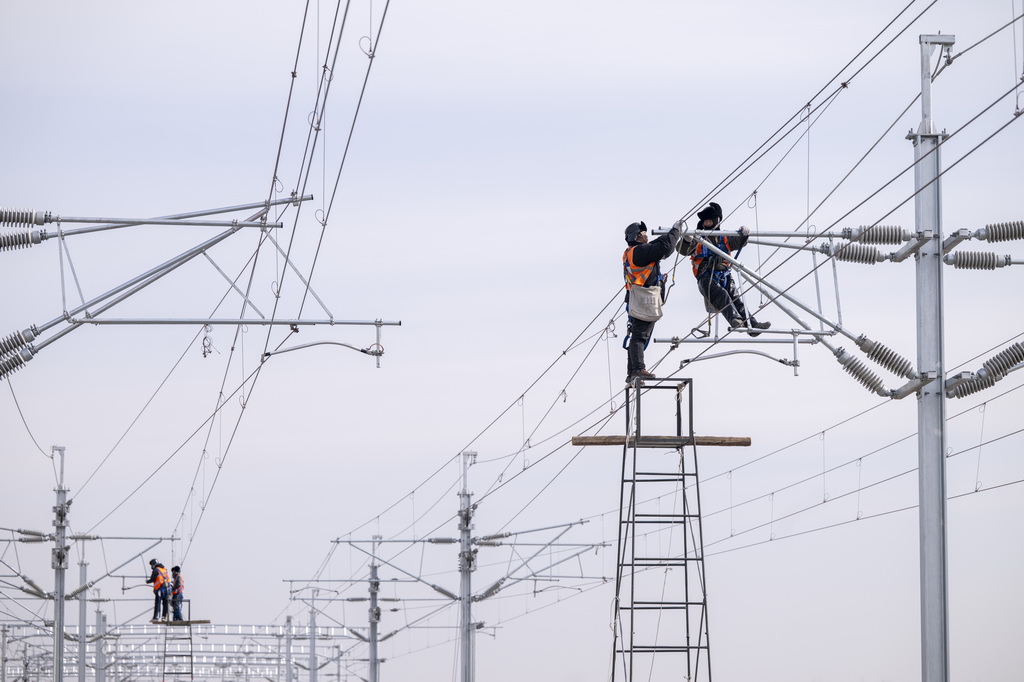 3月13日，工人在哈伊高铁绥化南站施工现场进行接触网作业。