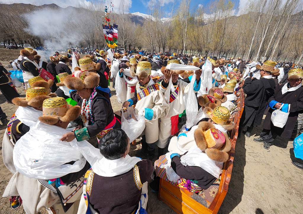 3月16日，人们为拖拉机手和撒种子的妇女献上哈达。