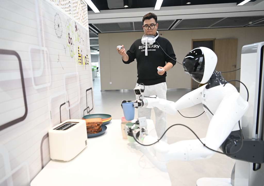 3月17日,在中國雄安集團數字城市科技有限公司具身智能訓練場,工作人員對機器人進行具身智能訓練。