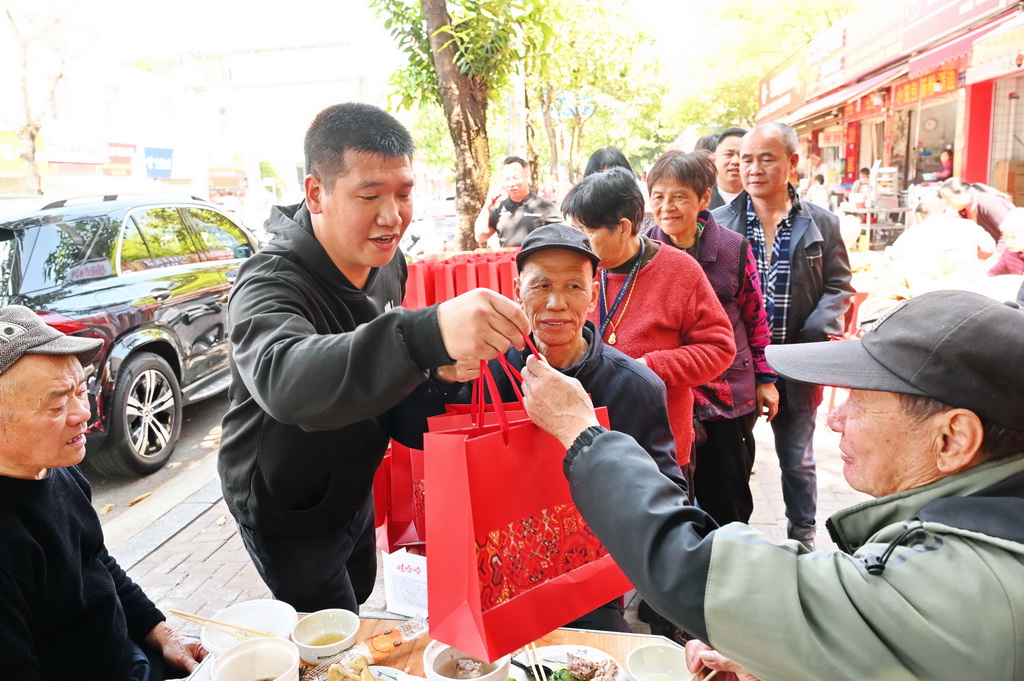 3月17日，在福州市仓山区后巷路，一位餐饮店主（左二）向老人赠送八宝粥、面包等礼品。