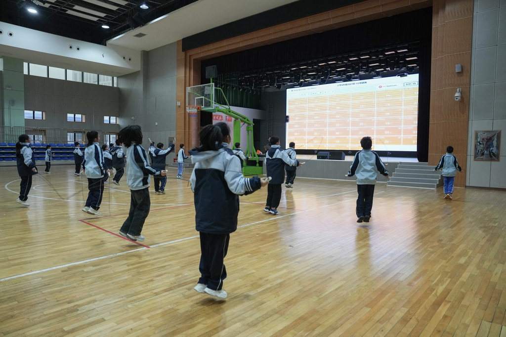 3月17日,学生在湖南湘江新区雷锋小学体育课上练习跳绳,他们的跳绳次数会实时投放到大屏幕上,帮助老师掌握每个学生的运动情况。
