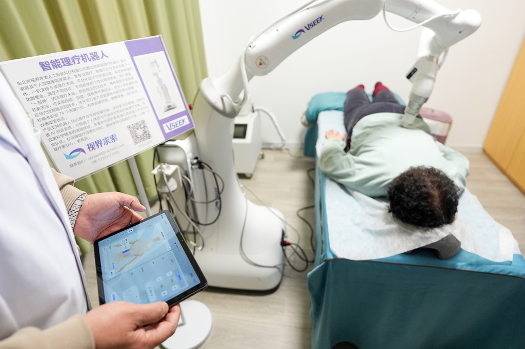 在智慧康养机器人养老驿站内,一名社区居民体验一款智能理疗机器人(3月18日摄)。