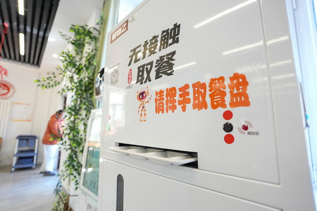 北京荣华街道智慧康养机器人养老驿站内的智能分餐盘机(3月18日摄)。