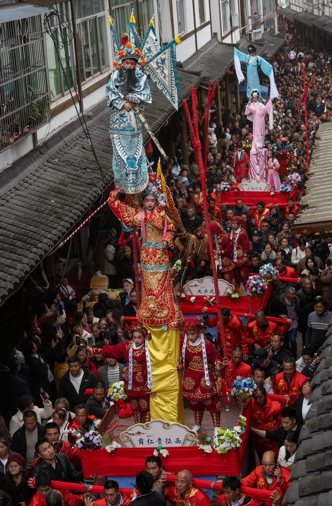 3月20日,四川省兴文县九丝城镇建武村,演员在巡游活动中表演木台铁桩戏。