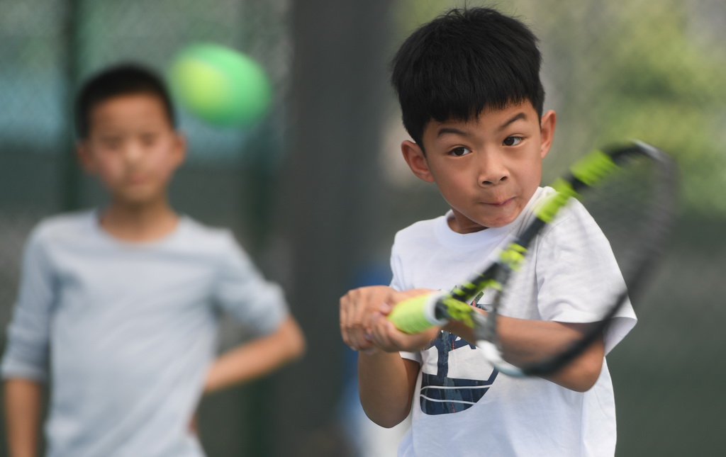 在湖北省京山市文峰公园网球场，一名小朋友在打网球（2024年3月22日摄）。新华社记者 杜子璇 摄