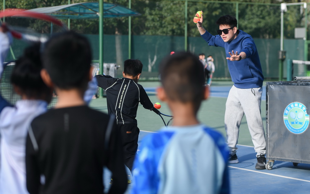 在湖北省京山市文峰公园网球场，教练指导孩子们打网球（2024年3月21日摄）。新华社记者 杜子璇 摄