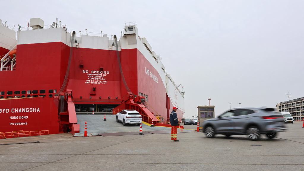 3月24日，工作人员在码头引导国产新能源汽车驶入汽车滚装船。