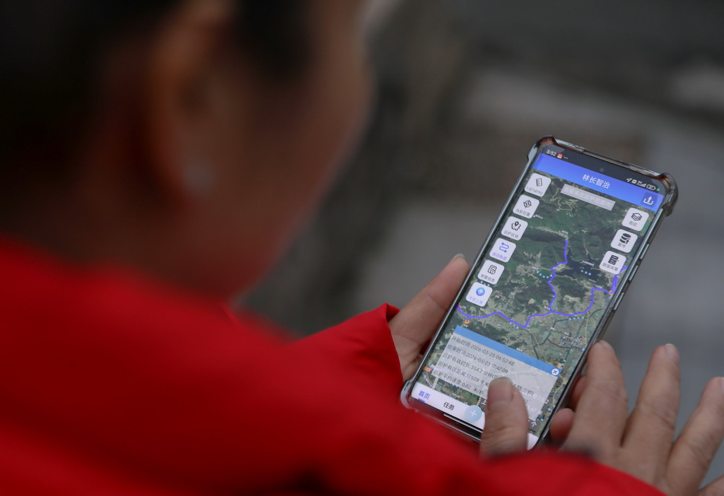 3月23日,在浙江省寧波市鎮海區九龍湖鎮,一名護林員查看手機上的巡護路線記錄。該鎮護林員須使用手機應用程序,在巡護點打卡,並記錄巡護路線、時長等信息,方便查漏補缺。新華社記者 杜瀟逸 攝