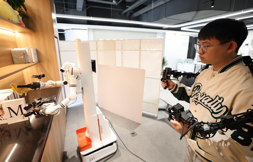 3月25日，在北京市石景山區首鋼園內的人形機器人數據訓練中心，工作人員在訓練機器人。