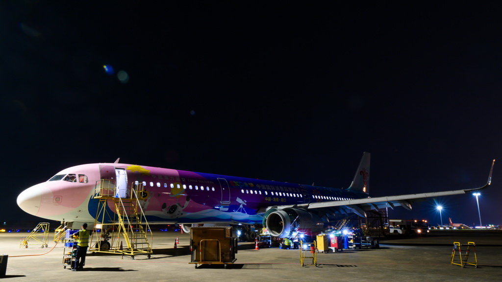 在海口美蘭國際機場停機坪上，南航工程技術分公司機務工程師對“消博號”彩繪飛機進行深度檢查（4月4日攝）。