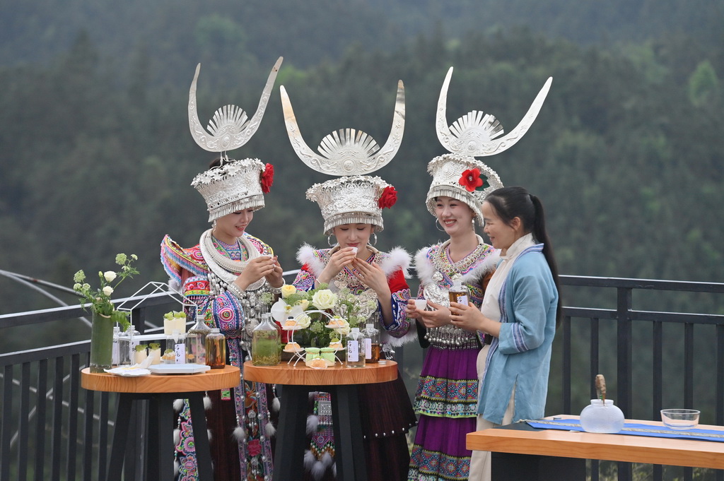 4月12日,在广西融水苗族自治县水融香粤桂协作现代农业产业园,人们在茶山上品茶。