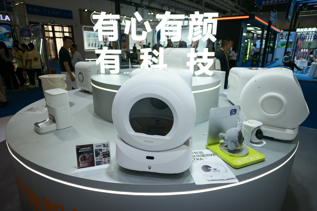 4月14日在第六届消博会科技消费展区拍摄的智能自动猫厕所、AI宠物机器人等宠物智能用品。