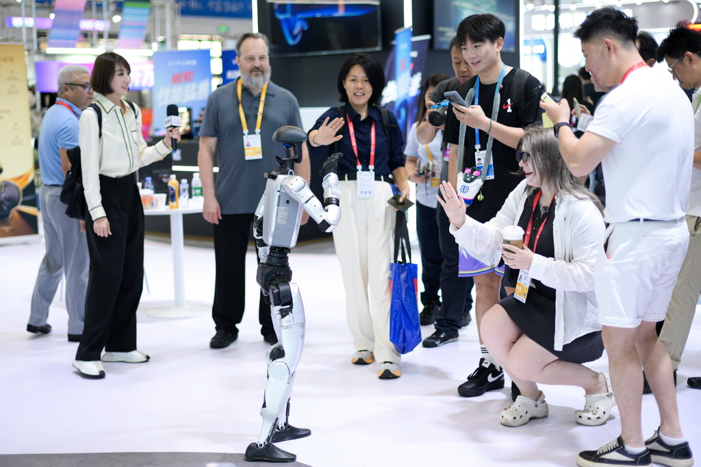4月14日，观众在第六届消博会科技消费展区与宇树机器人互动。