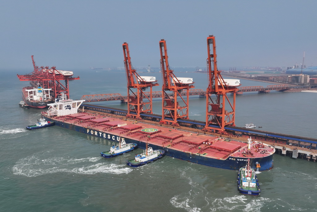 4月15日，一艘轮船在拖轮协助下向唐山港曹妃甸港区矿石码头靠泊（无人机照片）。