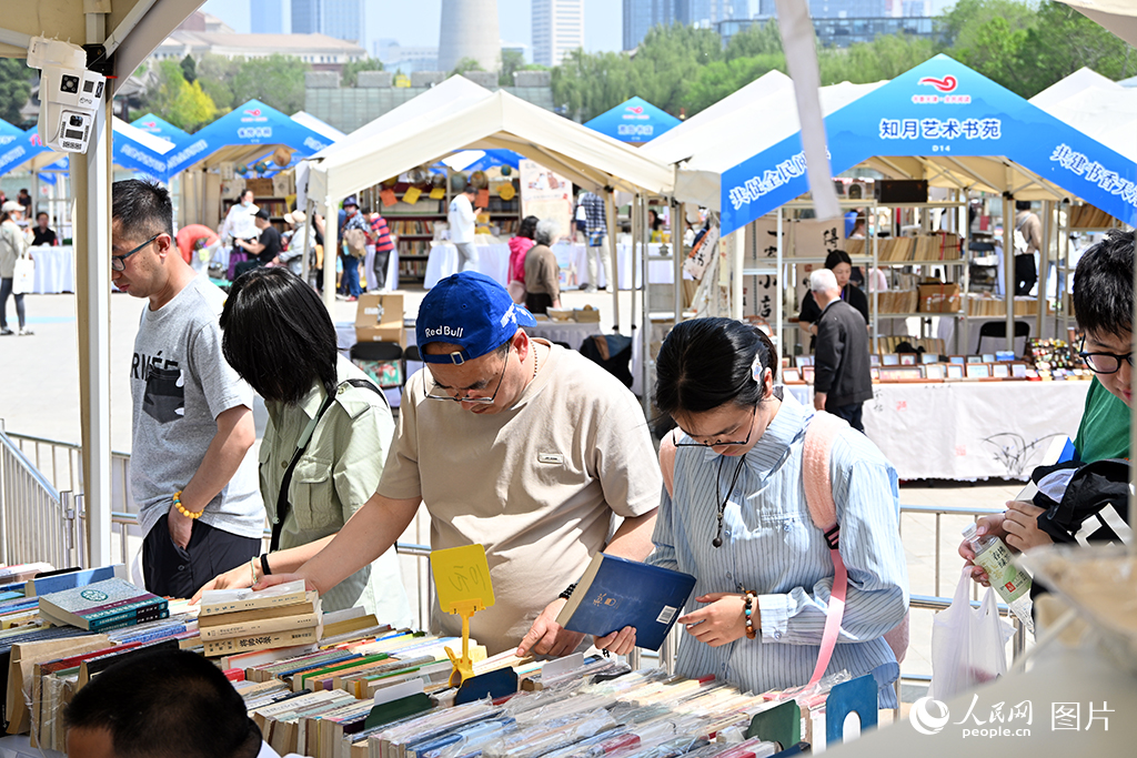4月18日至26日，主題為“共促全民閱讀，共建書香社會”的2026年海河書香節·水上公園書市活動在天津水上公園舉行。圖為4月18日市民正在書市上挑選喜愛的書籍。人民網記者 孫一凡攝