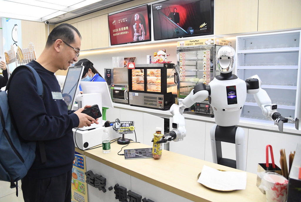 4月22日，在北京市海澱區中關村大街一座大廈內的便利店，機器人將抓取好的飲料交給顧客。