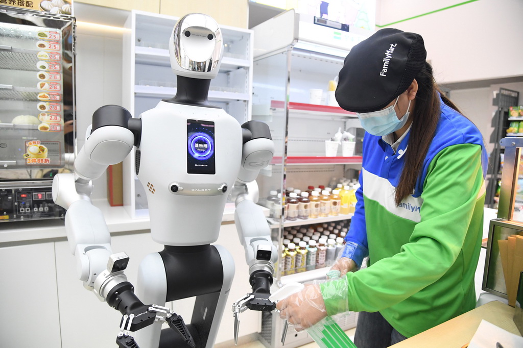 4月22日，在北京市海澱區中關村大街一座大廈內的便利店，工作人員為機器人的抓夾進行消毒。