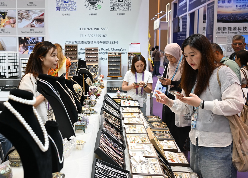 4月23日，采购商（右）在第139届广交会第二期的时尚饰品专区洽谈。