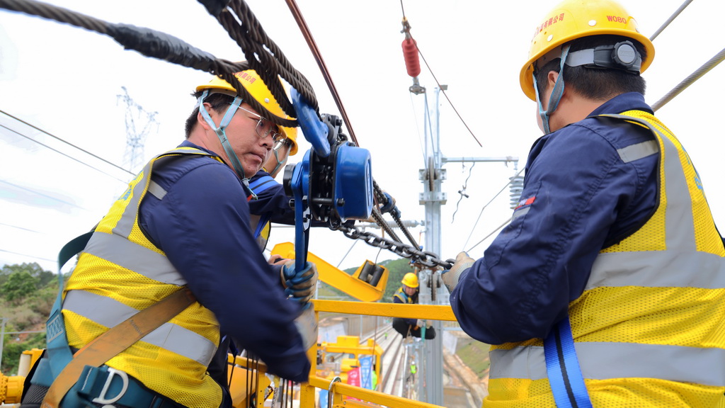 4月23日，南珠高鐵玉岑段首條接觸網導線在廣西玉林北至容縣南區間成功架設，這是施工人員在開展落錨作業。