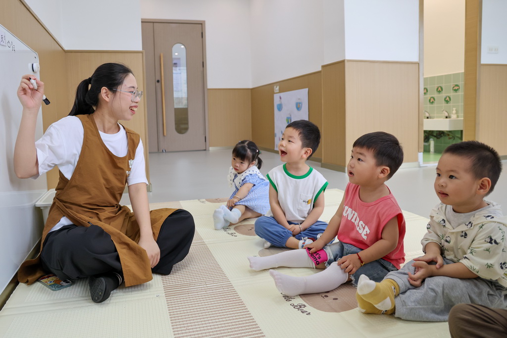 4月15日，在深圳市龙华区民治街道民康社区“一老一小”综合服务站，恩乐儿托育园的老师在陪孩子们做游戏。