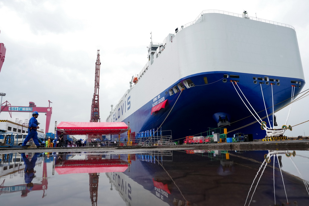 4月28日，一名工作人员从刚交付的运输船旁走过。