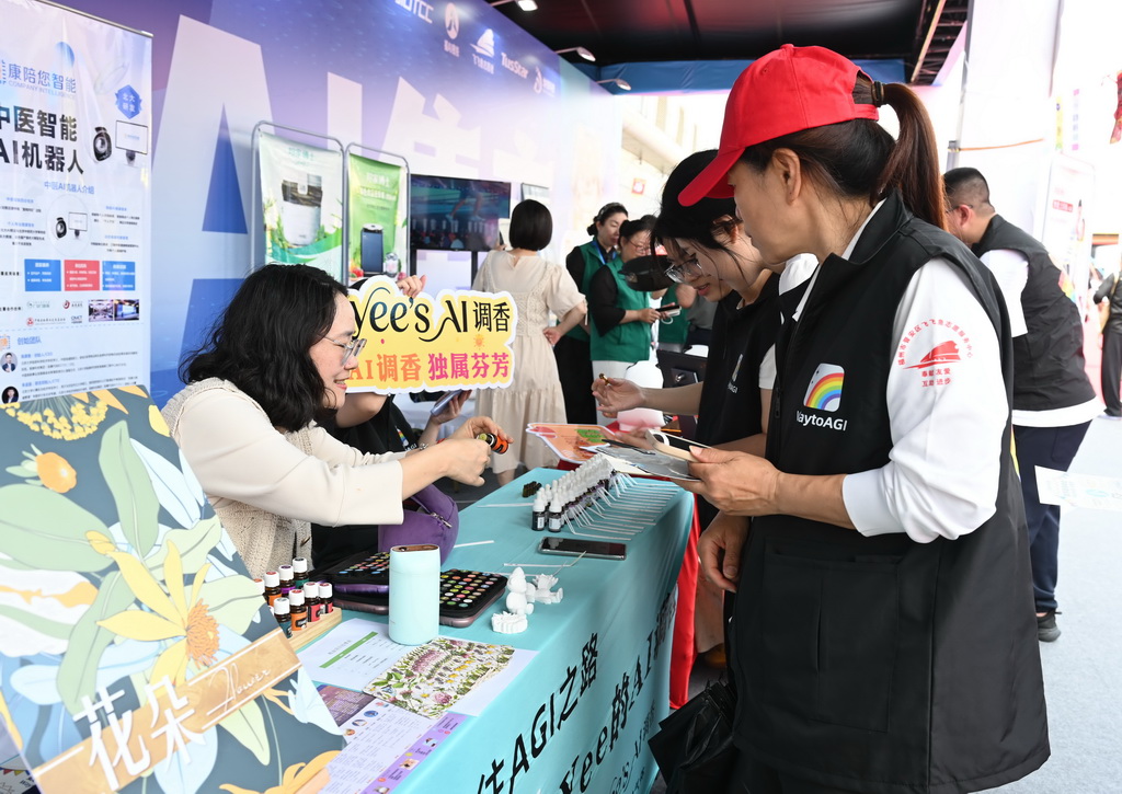 4月28日，OPC创业者（左）向参观者展示AI调香和AI精油。